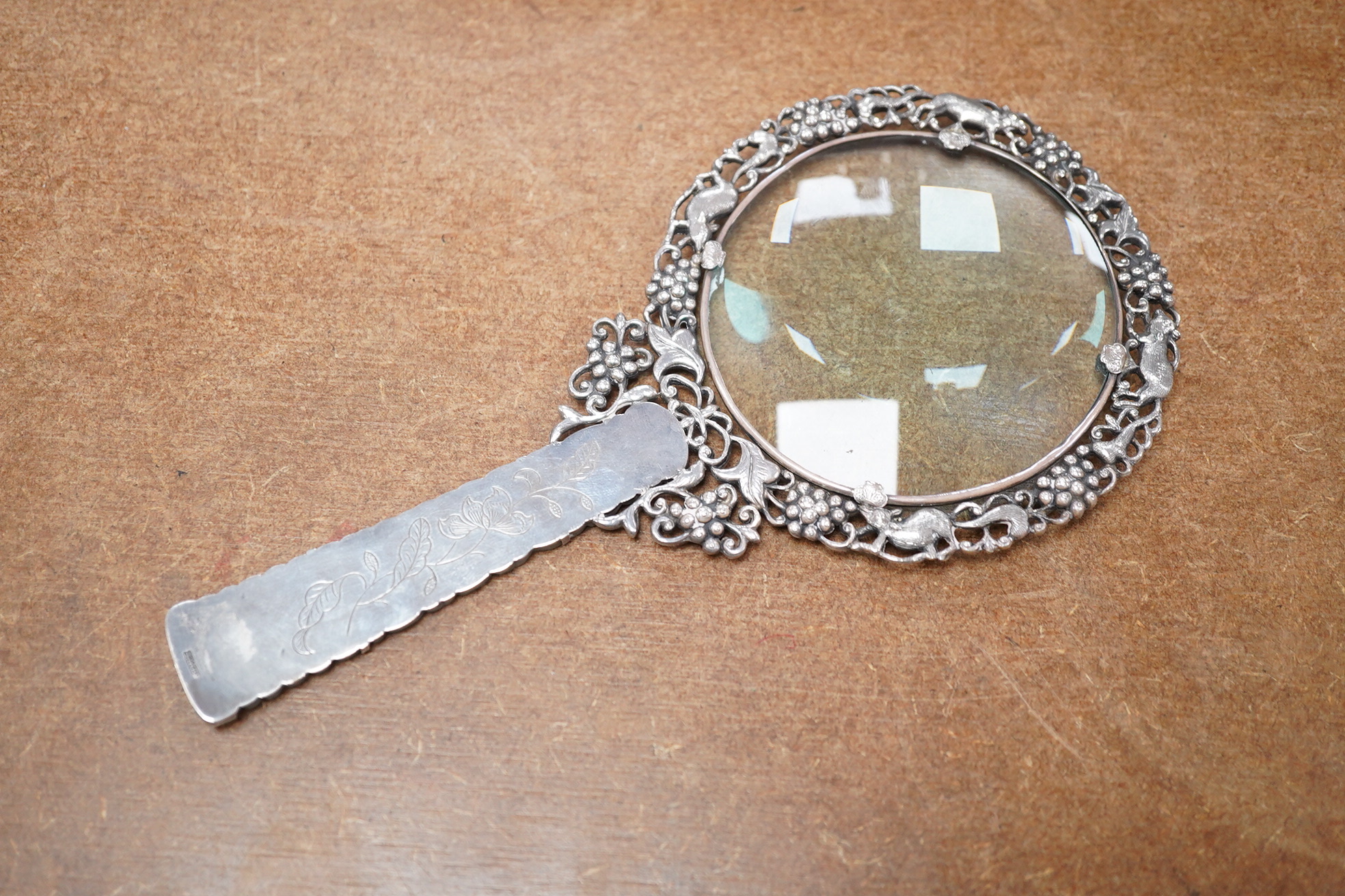 A Chinese white metal and pale celadon jade handled magnifying glass, early 20th century, stamped ‘SILVER’, 19cm long. Condition - good